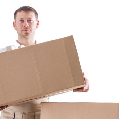 Mover with cardboard box in hands isolated on white background. Relocation services man with things. Loader worker in uniform with cardboardboxes.